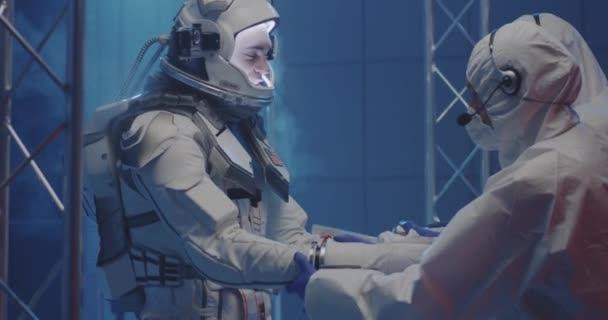 Vědec pomáhá astronautovi nasadit si rukavice — Stock video