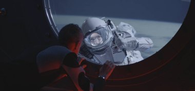 Astronot uzay yürüyüşü yapan mürettebatla konuşuyor.
