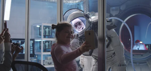 Astronauta dopasowanie dłoni z dziewczyną przed wyjazdem — Zdjęcie stockowe