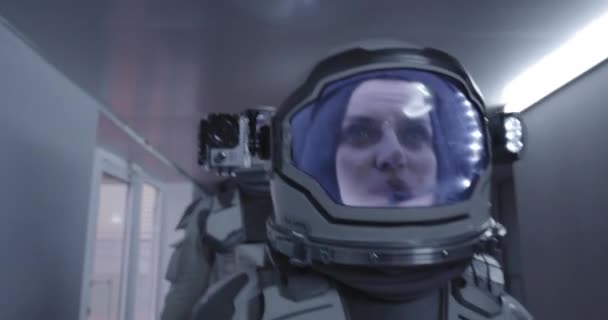 Женщина-космонавт, идущая по коридору — стоковое видео