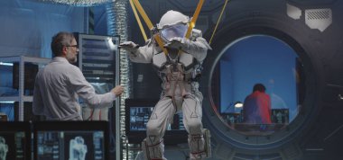 Astronot bant takarken kol ve bacaklarını hareket ettiriyor