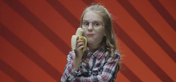 Kind eet bananen en klaagt tegen de camera — Stockfoto