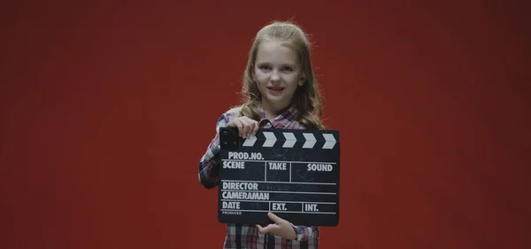 Dívka tleskání clapboard a zvedání obočí — Stock fotografie