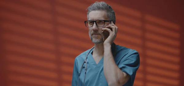 Manlig läkare som har ett telefonsamtal — Stockfoto