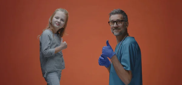 Κορίτσι και γιατρός δίνουν αντίχειρες στην κάμερα — Φωτογραφία Αρχείου
