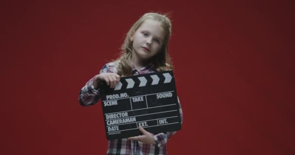 Girl clapping clapboard and raising eyebrows — Stock Video