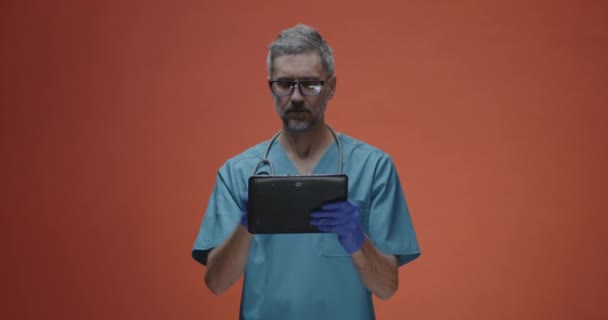 Médico varón usando un comprimido — Vídeos de Stock