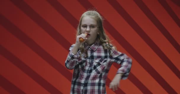 Mädchen isst Karotte und lächelt in die Kamera — Stockvideo