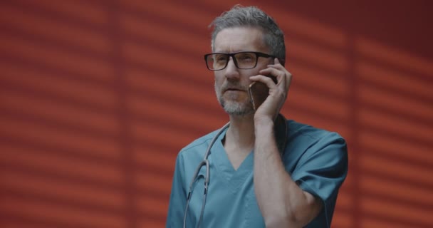 Männlicher Arzt telefoniert — Stockvideo