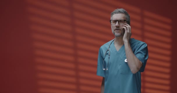 Erkek doktor telefon görüşmesi yapıyor. — Stok video