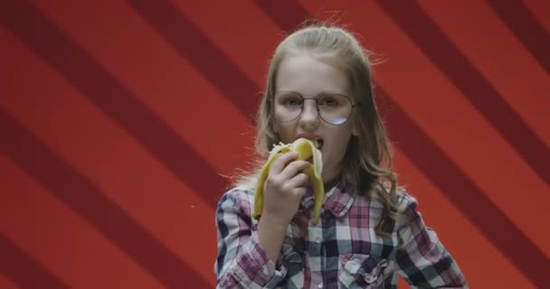Child eating banana and complaining to camera — Stock Video