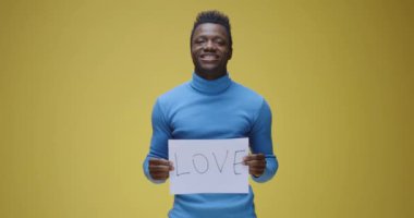 Genç adam tabela tutuyor.