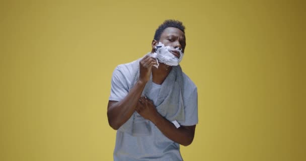 Молодой человек поет и танцует во время бритья — стоковое видео