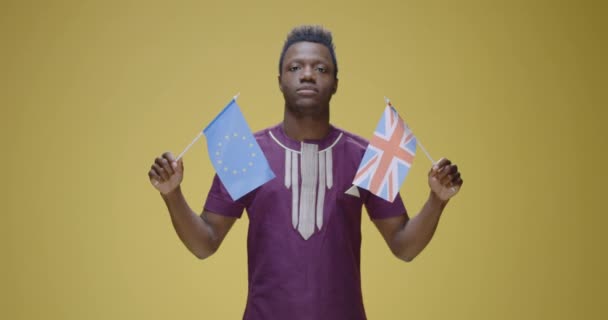 持怀疑态度的人拿着英国和Eu国旗 — 图库视频影像