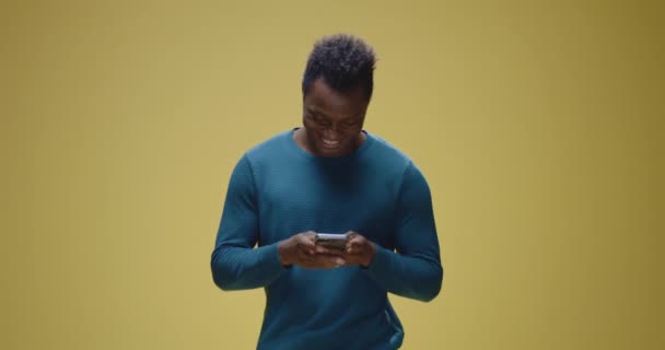 Joven hombre charlando en su teléfono inteligente — Vídeo de stock