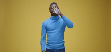 Adam şişeyi açıyor ve içiyor.