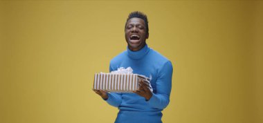 Genç adam hediyeyi yakalıyor.