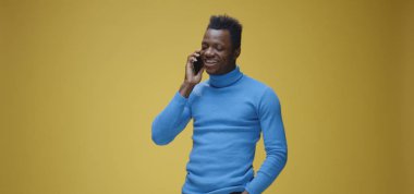 Genç adam telefonda konuşuyor.