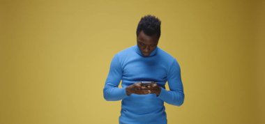 Genç adam telefonda görüntülü konuşma yapıyor.