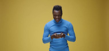 Genç adam telefonda görüntülü konuşma yapıyor.