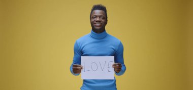 Genç adam tabela tutuyor.