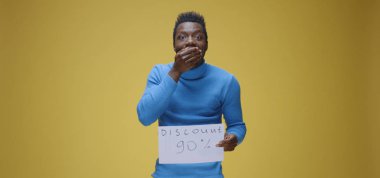 Genç adam tabela tutuyor.