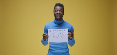 Genç adam tabela tutuyor.