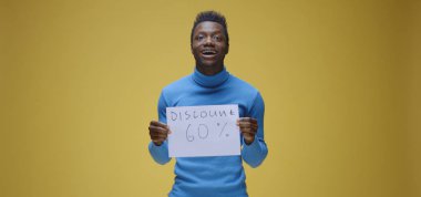 Genç adam tabela tutuyor.