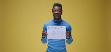 Genç adam tabela tutuyor.