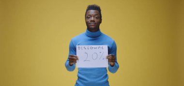 Genç adam tabela tutuyor.