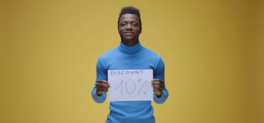 Genç adam tabela tutuyor.