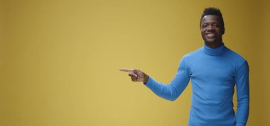 Gülümseyen genç adam sağı işaret ediyor