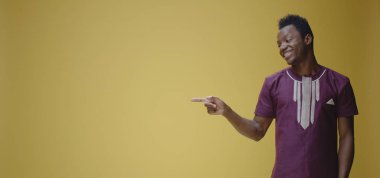 Gülümseyen genç adam sağı işaret ediyor