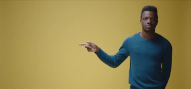 Gülümseyen genç adam sağı işaret ediyor