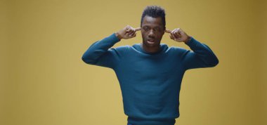 adam elleriyle kulaklarını kapsayan