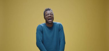 Ağzı bantlı bir adam kameraya bakıyor.