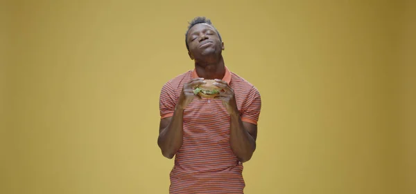 Junger Mann isst zwei Sandwiches — Stockfoto