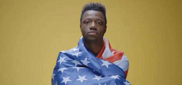 Молодой человек, поднимающий флаг США — стоковое фото