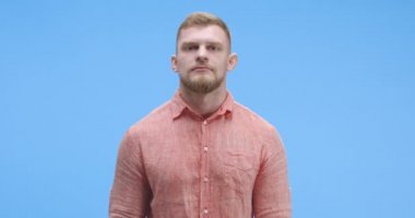 Genç adam göz kırpıyor.