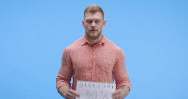 İndirim levhası tutan genç adam.