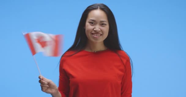 Jonge vrouw zwaaiend met Canadese vlag — Stockvideo