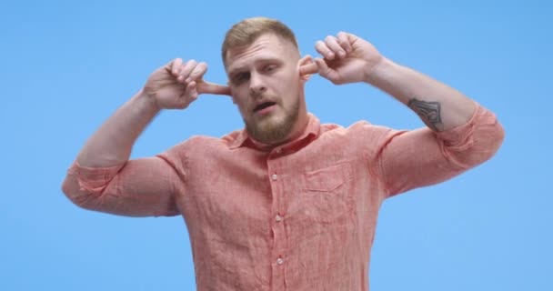Mladý muž si zacpává uši — Stock video