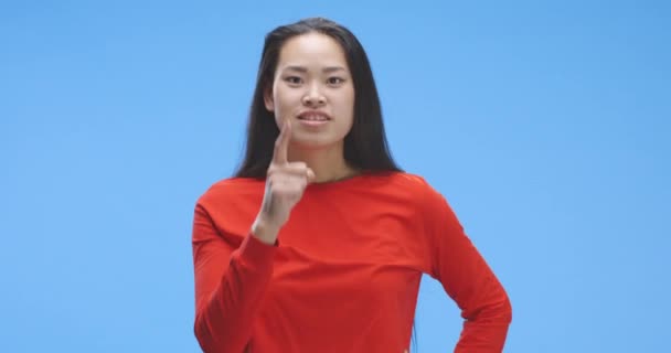 Ung kvinna som förklarar medan du pekar på kameran — Stockvideo