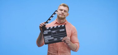 Canı sıkılan adamın elinde klaket var.