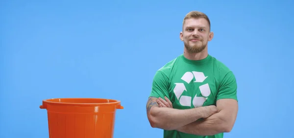 Hombre eco-consciente poniendo botella en cubo — Foto de Stock