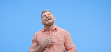 Genç adam neşeyle gülüyor.