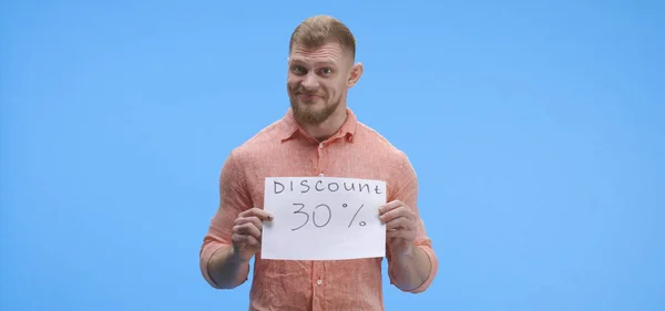 Young man holding discount sign — Stock Photo, Image