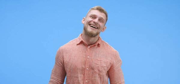 Молодой человек весело смеется
