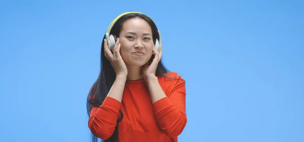 Jovem mulher ouvindo música em fones de ouvido — Fotografia de Stock