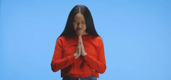 Mujer joven rezando delante de la cámara — Foto de Stock